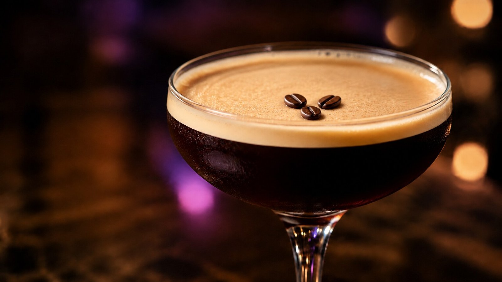 Espresso Martini im Neonlook Espresso Martini mit drei Kaffeebohnen vor stark verschwommenem kaffeebraunem Licht