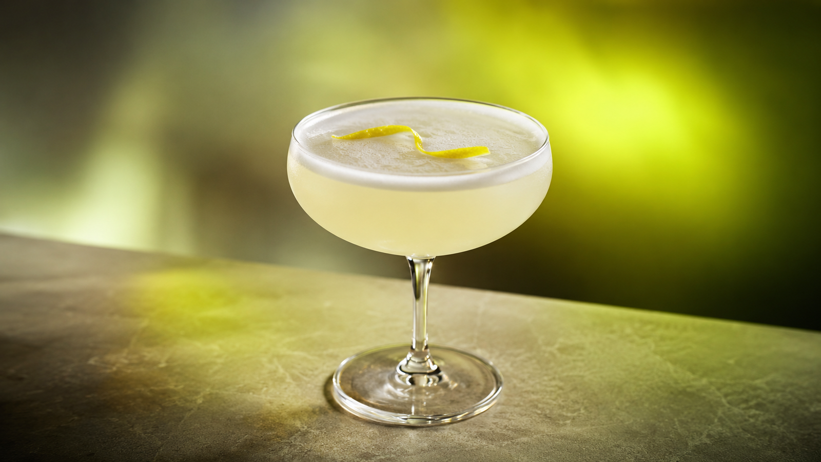 Gin Sour vor extrem unscharfem Neonhintergrund in der Farbe des Drinks