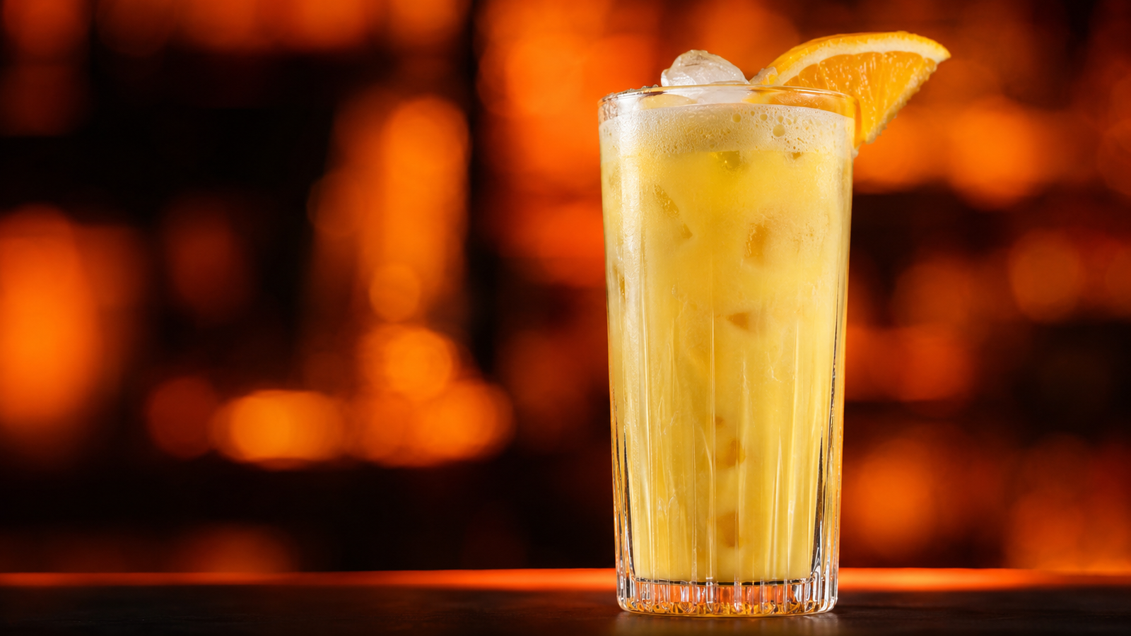 Solero Cocktail vor extrem unscharfem Neonhintergrund in der Farbe des Drinks